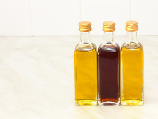 Three vegetable oil bottles on white kitchen table.