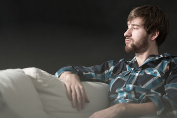 Fototapeta premium Depressed man is sitting on couch