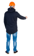 Back view of an engineer in  construction helmet stands.