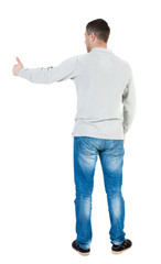 Back view of  man in shirt shows thumbs up.