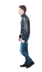 Naklejka premium Back view of going handsome man in jacket. walking young guy