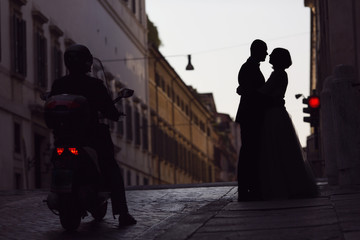 Silhouette of a young bride and groom lover on street of Rome, I