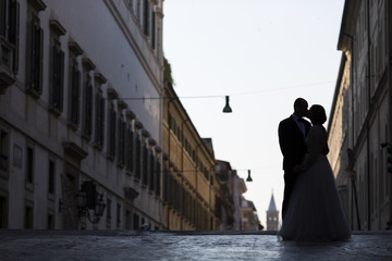 Silhouette of a young bride and groom lover on street of Rome, I