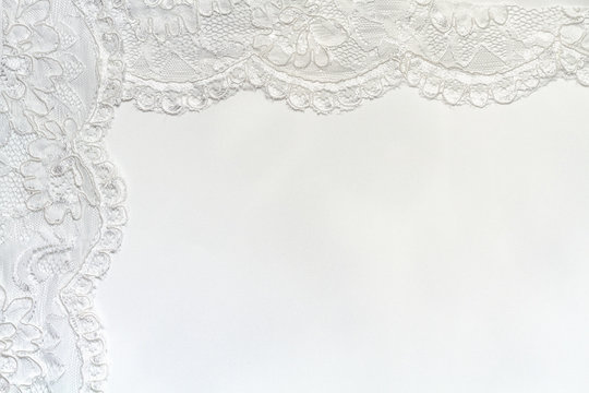 White Delicate satin background with lace border.