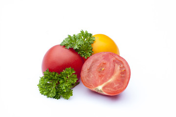 Red and yellow tomato and parsley on the white isolatd background, selective focus