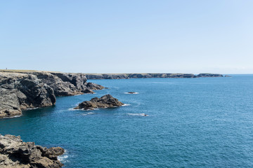 cliff of the wild coast of a brittany island dropping into the ocean