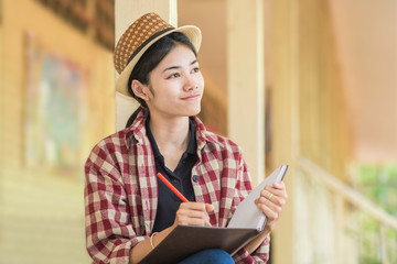 Woman is recording in the book of her creativity.