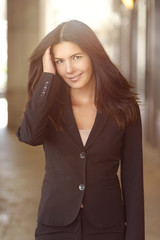 Brunette Businesswoman Outdoors with Hand in Hair