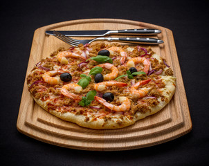 Tuna pizza with shrimp and cutlery