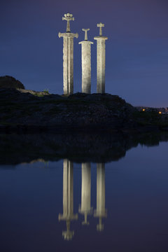 The Three Swords Monument at night, Stavanger, Norway. Called Sverd i Fjell  in Norwegian, it is located in a popular recreation area on the shore of  Hafrsfjord. Stock Photo | Adobe Stock