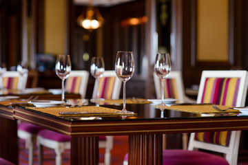 Empty wine glasses on restaurant table/Empty glass wine glasses on a wooden table in a restaurant