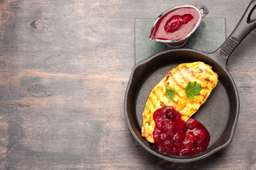 Grilled chicken breast in a frying pan with berry sauce. Top view, space for text