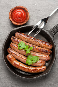 Grilled homemade sausages in a pan. Top view