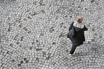 Fototapeta na wymiar Older women walking on cobblestone bird perspective