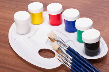 Malfarben in kleinen Eimer und einer Malpalette mit Pinsel © SENTELLO