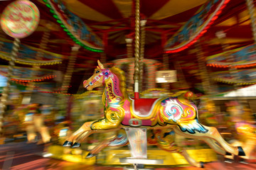 Fototapeta na wymiar Motion blurr of vintage horse of amusement ride on merry-go-roun