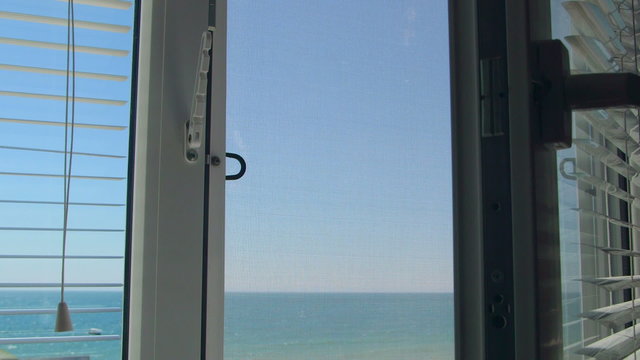 Sea view through the open white window