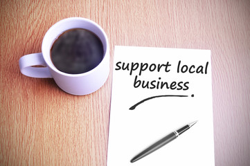Coffee on the table with note writing support local business