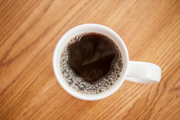 Steam and bubbles on a freshly poured cup of coffee