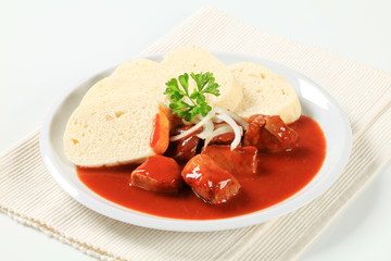 Pork meat in tomato sauce with raised dumplings