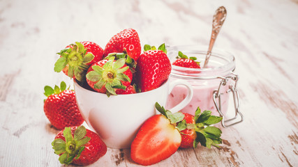 Spring fruits, strawberries with strawberry yogurt on a vintage