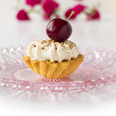 Cupcake with cherries, whipped cream and flowers