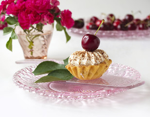 Cupcake with cherries, whipped cream and flowers