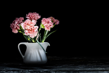 Flowers in a vase on wood black background-
