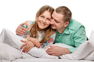 Couple lying in bed smiling