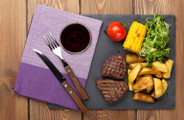 Steak with grilled potato, corn, salad and red wine