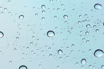 Water drop on sky glass mirror background.
