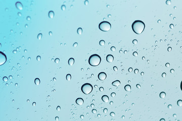 Water drop blue sky on glass mirror background.