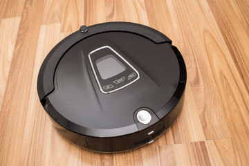 Robotic vacuum cleaner on wood parquet floor, Smart vacuum, new automate technology housework.