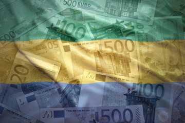 colorful waving gabonese flag on a euro money background