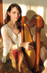 Woman plays celtic harp in folk style