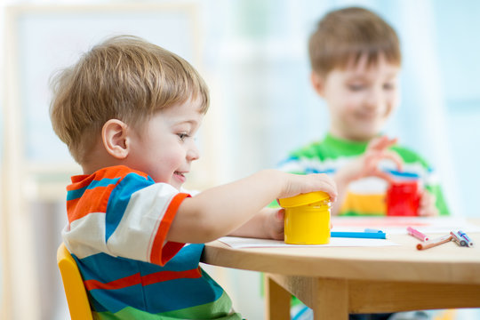 children play and paint at home or kindergarten or playschool or daycare