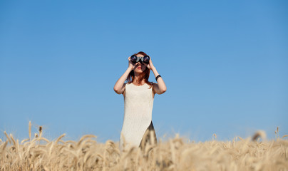 girl with binocular at wheat field.