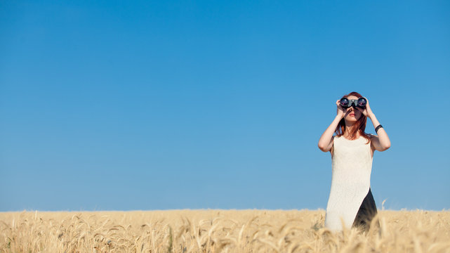 girl with binocular at wheat field.