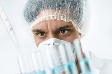 Keen scientist with brown eyes in protective wear loads samples
