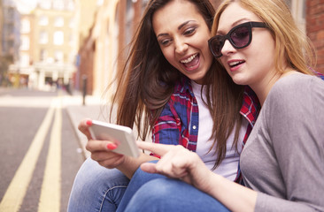 Two best friends sitting on the pavement