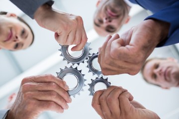 Business colleagues holding cog