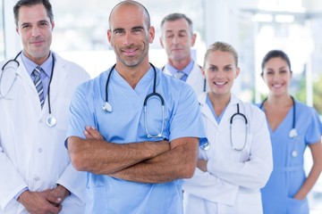 Team of smiling doctors looking at camera with arms crossed