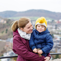  little child and young mother enjoying view city from above