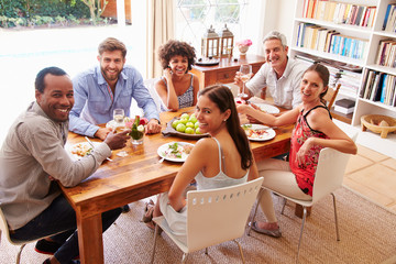 Friends sitting at a dining table looking at the camera