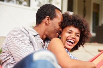 Obraz premium Laughing couple cuddling in a hammock