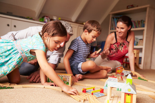 Parents playing with kids and toys in an attic playroom