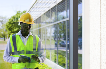 Worker inspector  in helmet checking  modern building  