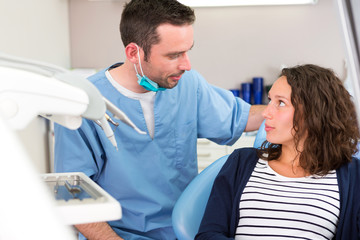 Young attractive dentist explaning his work to a patient