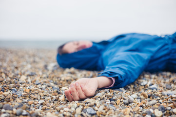 Unconscious woman on shingle beach
