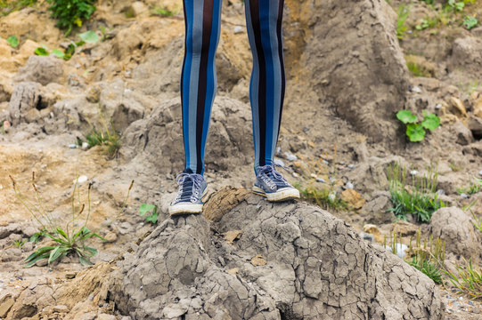 Legs of woman standing on mound of dirt